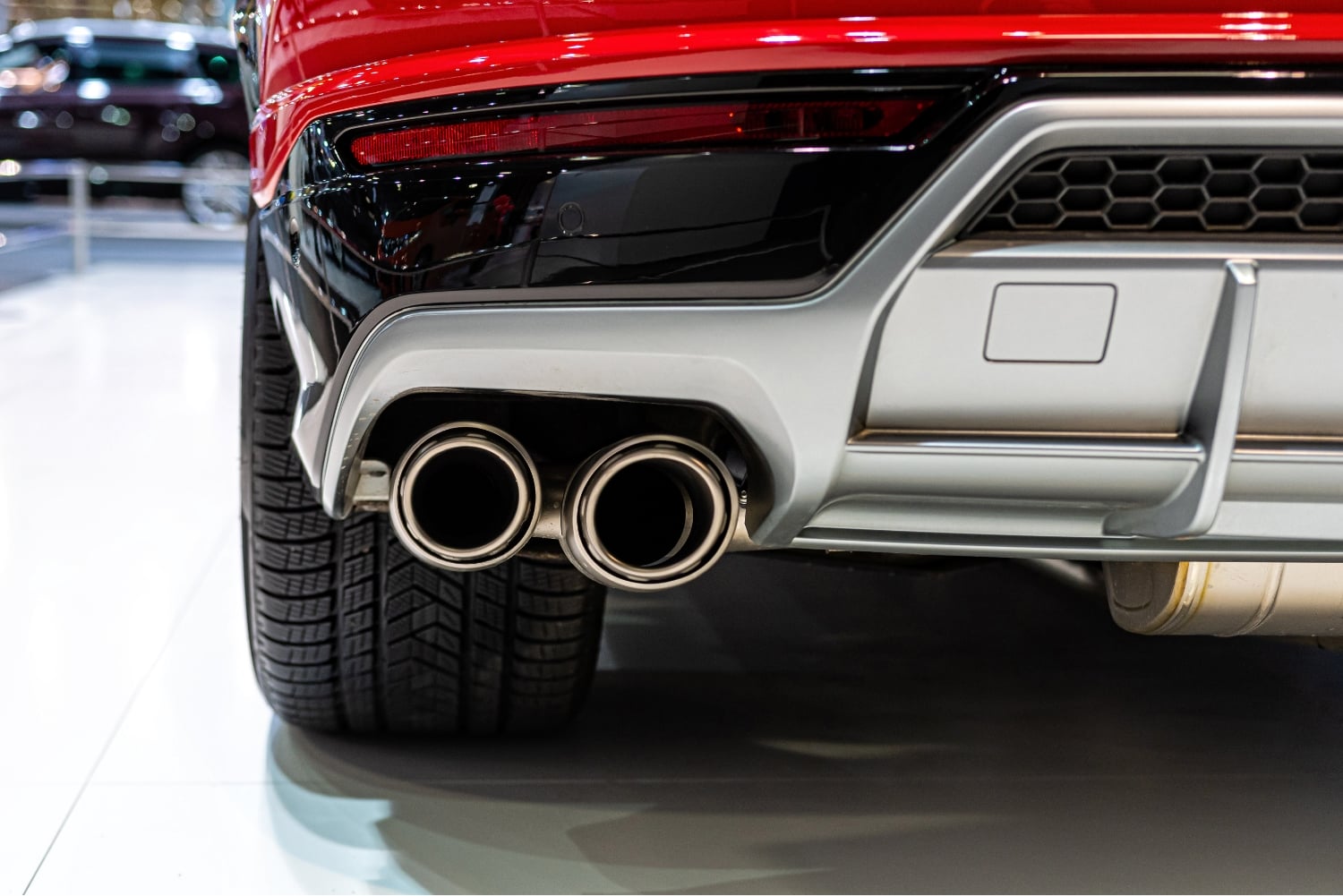 A cars exhaust pipes and read tail lights.